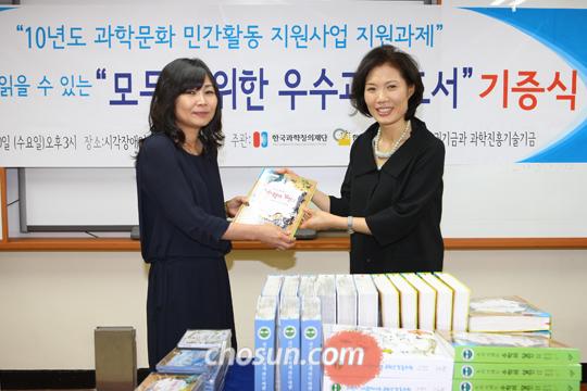 한국과학창의재단 강혜련 이사장(오른쪽)이 시각장애인가족 이란경 회장(왼쪽)에게 우수과학도서를 기증하고 있다
