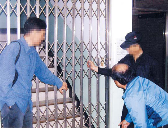 
	지난 2010년 서울 강북에 있는 J아파트 관리사무소 2층 입주자대표회의실로 올라가는 계단이 ‘철제 셔터’로 막혀 있다. 이 아파트 감사 A씨(왼쪽)가 “들어가게 해달라”고 요구하자, 관리사무소 직원이 막고 있다
