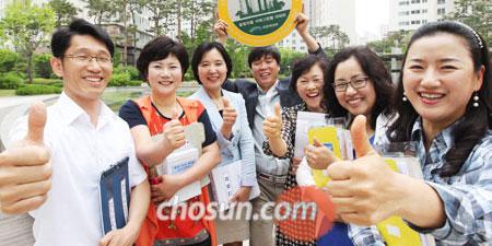 
	경기도 화성시 서해그랑블 아파트 김선자(왼쪽에서 셋째) 관리소장과 김현무(가운데 팻말 든 사람) 입주자대표회장 등이 엄지손가락을 내보이며 활짝 웃고 있다.
