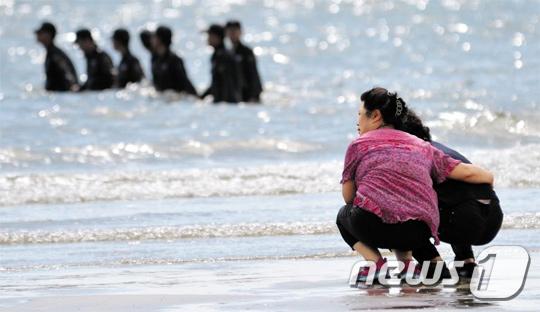 
	충남 태안 해병대 사설 캠프에서 고교생 5명이 실종된 사고가 일어난 다음 날인 7월 19일 오전, 실종자 가족이 백사장해수욕장에서 해경의 수색작업을 바라보고 있다. 실종자 5명의 시신은 이날 모두 인양됐다. /뉴스1
