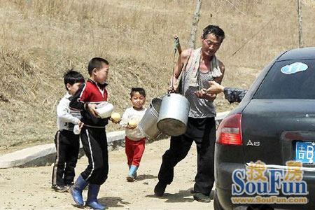 
	 북한을 방문한 중국 관광객들이 승용차를 타고 가던 중 차창 밖으로 북한 어린이와 주민에게 사탕을 던져주고 있다.
