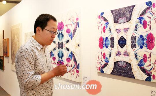 '문화역서울 284'(옛 서울역사)에서 열리고 있는‘2013 아시아프’를 관람 중인 화가 사석원씨.‘