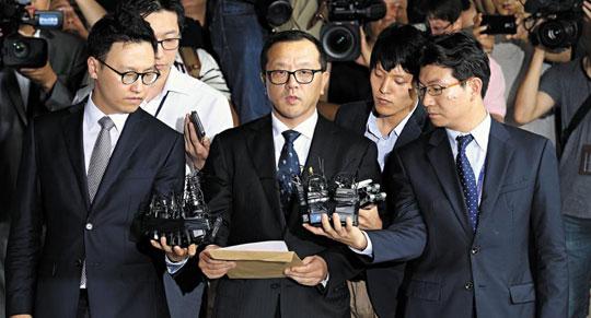 
		전두환 전 대통령의 장남 재국(가운데)씨가 10일 오후 미납 추징금 1672억원의 납부계획서와 이행각서 등을 들고 서울지검에 들어서며 기자들의 질문에 답하고 있다. /이덕훈 기자
