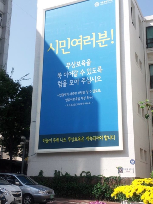 서울시의회 건물 벽에 영유아 보육법 개정을 촉구하는 내용의 대형 광고판이 걸려 있다./이애란 페이스북 캡처