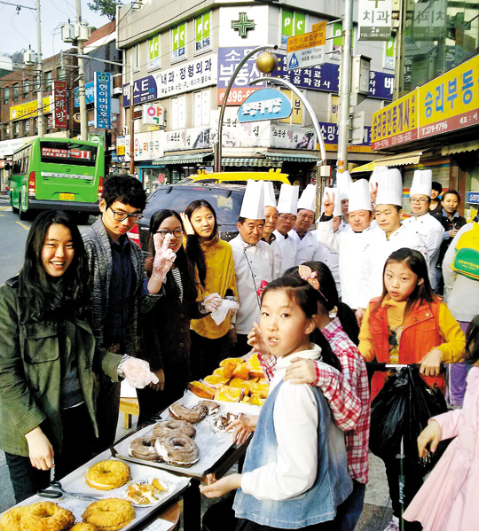 
 서울 서대문·은평 지역의 동네 빵집 살리기 프로젝트인 ‘동네빵네’의 시식 행사에서 베이커리 사장들과 연세대 학생들, 지역 주민들이 환하게 웃고 있다
