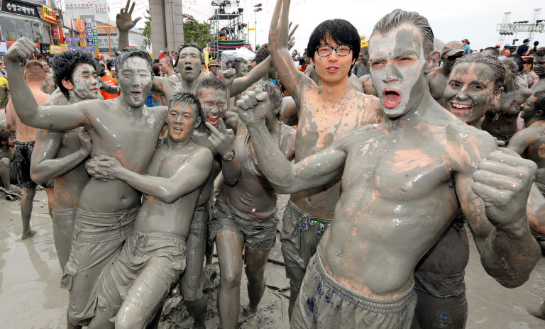 보령 머드축제 현장에서 세계 각국 남녀 관광객들이 진흙에 파묻혀 함께 즐기고 있다.