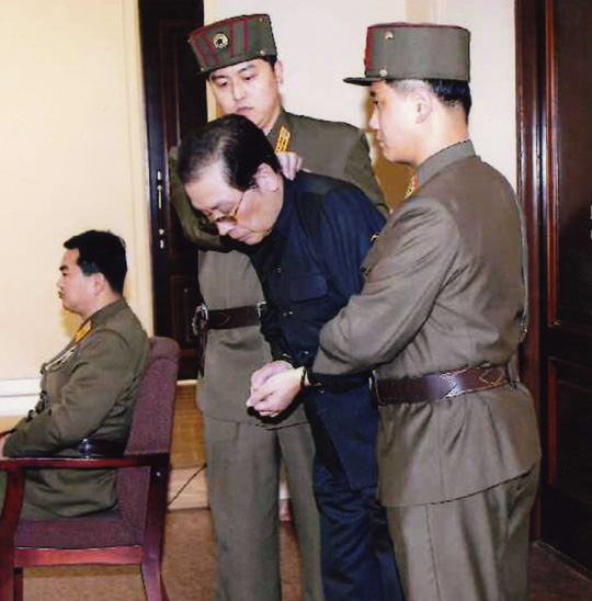 
	북한 노동신문이 지난 12일 장성택 처형 이후 공개한 사진. 포승줄에 묶인 장성택이 국가안전보위부 요원들에게 끌려 법정에 들어서고 있다

