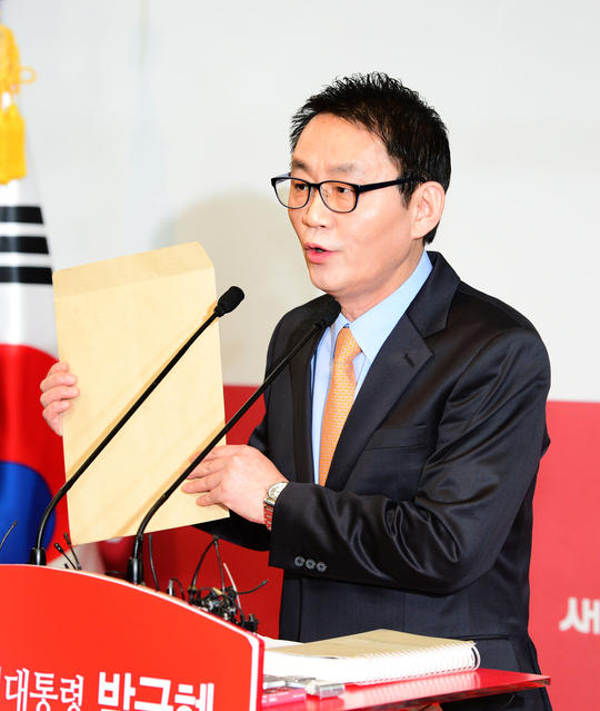 윤 대변인이 인수위원장 인선결과를 발표하면서 봉투를 뜯는 퍼포먼스를 펼치고 있다.