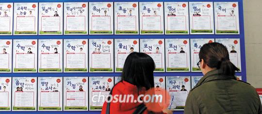 
	26일 오후 서울 동작구 노량진역 주변 임용고시학원 입구에서 학원 수강생들이 수업 안내판을 살펴보고 있다
