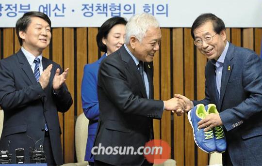 “신발 닳도록 뛰어주세요” 김한길 새정치민주연합 공동대표가 22일 서울 여의도 국회에서 열린 당 소속 시·도지사 당선자와의 예산·정책 협의회에서 박원순 서울시장에게 운동화를 선물하며 악수하고 있다. 김 대표는 이날 안철수(맨 왼쪽) 공동대표와 함께 당선자들에게 ‘신발이 닳도록 뛰어달라’는 의미로 당 상징색인 파란색 운동화를 선물했다.