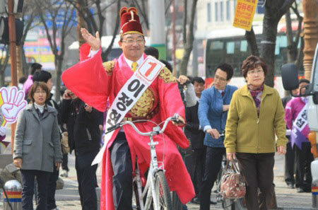 2012년 19대 총선 광주 서구을에 출마한 새누리당 이정현 후보가 이색복장에 자전거를 타고 선거운동을 하고 있는 모습./뉴스1