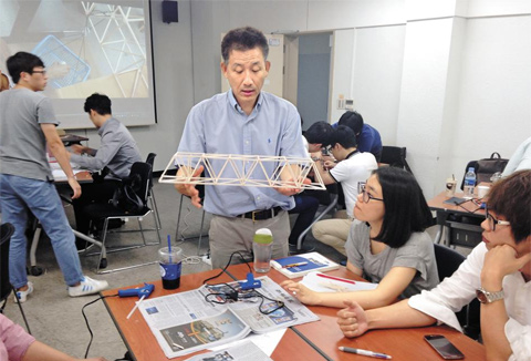 중앙대 공대의 한 교수(가운데)가 인문·사회·상경계열 전공인 두산중공업 직원들에게 트러스트 교각 제작 과정을 설명하고 있다. 두산중공업은 지난해부터 주니어급 직원들을 대상으로 ‘인문·사회 계열 전공을 위한 기초 공학’ 과정을 개설해 가르치고 있다.