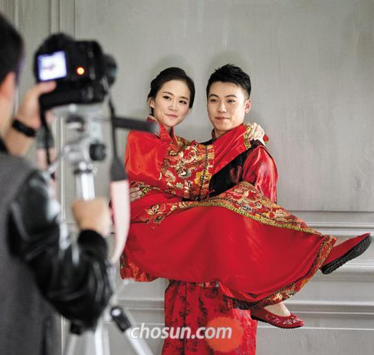 
  15일 오후 서울 강남구 삼성동 한 웨딩스튜디오에서 중국인 예비부부가 전통 의상을 입고 결혼 사진을 찍고 있다. 이 예비부부가 사진 촬영, 메이크업, 드레스 대여를 포함한 1박2일 일정을 소화하는 데 지불한 돈은 430만원이었다. /김지호 기자
