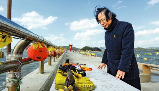 이주영 장관이 전남 진도 팽목항 방파제에서 세월호 실종자 가족이 자식·부모의 귀환을 염원하며 가져다 놓은 신발을 침통한 표정으로 바라보고 있다. 방파제에는 노란 리본과 함께 석가탄신일에 매단 연등(燃燈)이 그대로 달려 있다. 