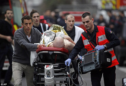 
	파리 소방대원들이 총격으로 부상당한 사람을 구급차로 옮기고 있다./AP 제공
