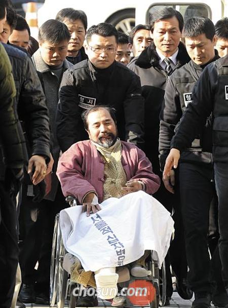 마크 리퍼트 주한 미국대사를 테러한 혐의로 구속영장이 청구된 김기종이 6일 영장실질심사 출석을 위해 서울중앙지법으로 들어서고 있다. 김은 살인미수·외국사절폭행·업무방해 혐의를 받고 있다. 이날 오후 10시 40분 법원이 구속영장을 발부함에 따라 김은 종로경찰서 유치장에 수감됐다.