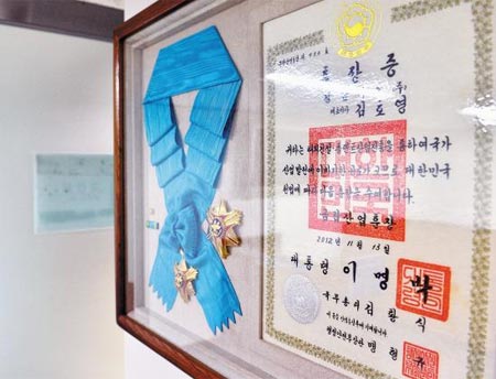 
		서울 동대문에 있는 경남기업 본사 1층 벽에 이명박 전 대통령이 경남기업 대표이사에게 수여한 금탑산업훈장과 훈장증이 걸려 있다. /뉴시스
