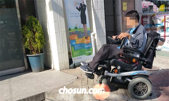 
	17일 전동 휠체어를 탄 지체 장애인이 서울 동작구 한 파출소 입구의 좁고 가파른 경사로를 오르려 하고 있다.
