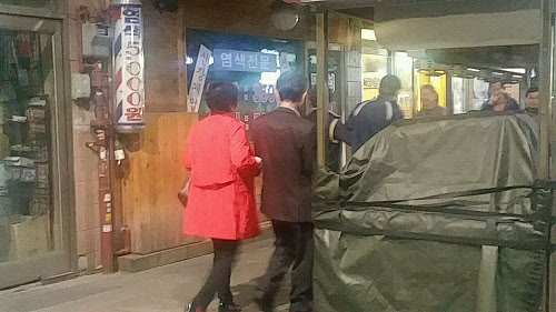 22일 밤 11시쯤 서울 종로3가 골목에서 빨간 외투를 입은 '올빼미 아줌마'가 말끔한 정장 차림의 남자와 팔짱을 끼고 걷고 있다./이벌찬 기자