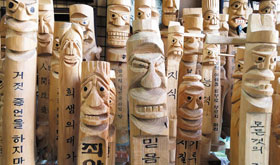 가게 창문 앞으로 빽빽하게 진열해놓은 소형 장승들.