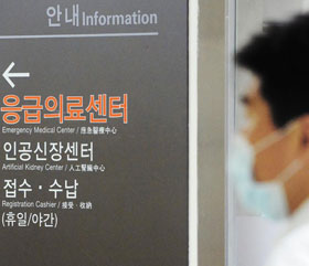 서울 강동경희대병원 투석실에서 치료받던 환자가 메르스 확진 판정을 받아 병원내 추가 감염자가 나오는 게 아니냐는 우려가 나오는 가운데, 18일 이 병원 관계자가 마스크를 쓴 채 인공신장센터 앞을 지나가고 있다.