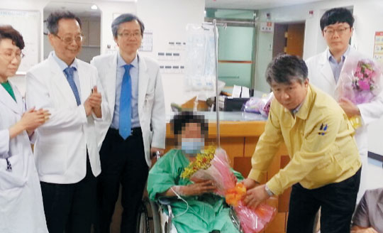 동국대경주병원에서 메르스 치료를 받은 홍모(77)씨가 20일 의료진의 축하 꽃다발을 받으며 퇴원하고 있다.