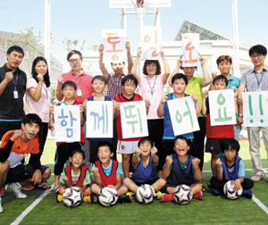서울 강동구도시관리공단 직원과 유소년 축구 교실 청소년들이 19일 통일나눔펀드에 100만원을 기부한 뒤 활짝 웃고 있다.