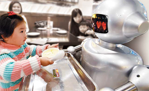 가파른 임금 상승과 경제활동인구 감소세 등의 영향으로 중국에서 로봇 산업이 급성장하고 있다. 지난 1월 중국 안후이성 허페이시(合肥市) 한 식당에서 웨이터 로봇이 아이에게 음식을 서빙하고 있다. 웨이터 로봇은 바닥에 그려진 경로를 따라 움직이기 때문에 장애물에 부딪히지 않으면서 서빙이 가능하다.