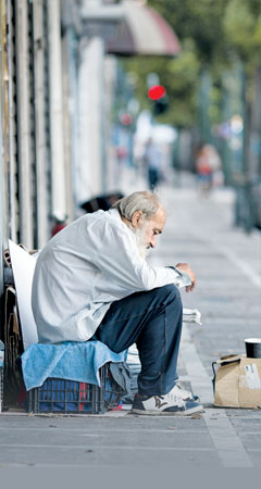지난 7월 13일 그리스 아테네의 한 거리에서 노숙자가 행인에게 구걸하고 있다. 