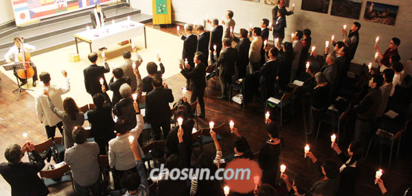 21일 독일‘베를린 비전교회’에서 열린 평화의 페스티벌 음악회 참석자들이 촛불을 들고 합창을 하고 있다.