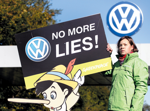 폴크스바겐(Volkswagen)의 공장 정문 앞에는 환경보호 단체 그린피스의 한 회원이 배기가스 조작에 항의하는 포스터를 들고 서 있었다.