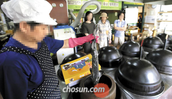 지난 30일 서울 강남구 대치동의 한 건강원에서 직원이‘물범탕’을 제조하기 위해 물범과 철갑상어 등 재료를 압력솥에 넣는 모습을 학부모들이 지켜보고 있다.