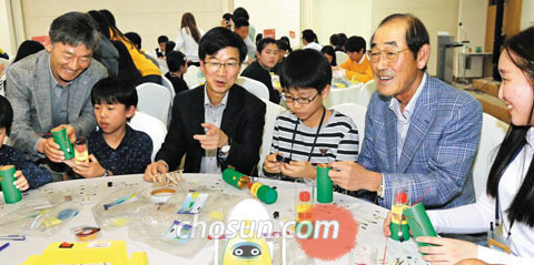 17일 한국공학한림원이 서울대에서 개최한‘공학한마당’행사에서 윤종용(오른쪽에서 둘째) 국가지식재산위원회 위원장과 박성욱(오른쪽에서 넷째) SK하이닉스 사장, 이학성(〃여섯째) LS산전 최고기술책임자가 초등학생들과 과학 원리가 적용된 모형을 만들고 있다.