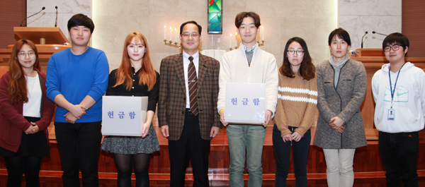 안산대 김재중 교목실장(왼쪽에서 넷째)과 학생·교직원이 예배실에서 헌금함을 들고 서 있다.