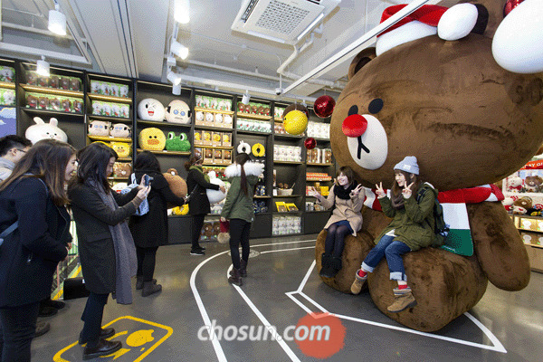 지난 5일 오후 서울 신사동 가로수길에 있는 ‘라인프렌즈’ 매장 앞에서 고객들이 대형 ‘브라운’ 인형과 사진을 찍고 있다.