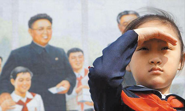 다큐 영화‘태양 아래’에서 주인공 진미(오른쪽)가 김정일을 그린 벽화를 배경으로 서 있다.