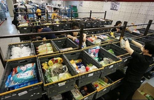 서울 이마트 용산점에서 직원들이 온라인으로 주문된 신선식품, 생필품을 배송 바구니에 담고 있다. / 조선일보DB