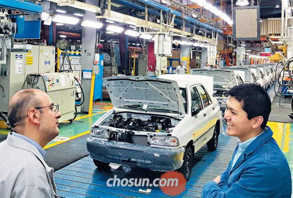 23일(현지 시각) 이란 수도 테헤란 외곽의 카라즈 산업단지에서 이란 자동차 회사인 ‘사이파’의 생산 라인이 가동되고 있다. 알리레자 이바다티(왼쪽) 사이파 대외관계부 부장이 코트라(KOTRA) 테헤란 무역관의 김욱진 과장과 대화하고 있다. 뒤에 보이는 차량은 사이파의 ‘사바’ 차종으로 1993년 한국 기아자동차의 구형 프라이드 생산 라인을 인수해 현재까지 자동차를 생산하고 있다.