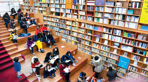 서울도서관은 방학을 맞은 어린이들에게 인기가 많다. 사진은 지난달 이 도서관 1층 아동도서 전용 서가 옆 계단에서 부모와 함께 책을 읽는 어린이들의 모습.