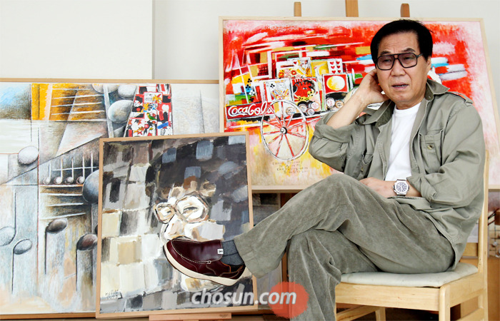 지난 2013년 서울 청담동 자택에서 자신의 회화 작품을 배경으로 앉은 가수 조영남. 꾸준히 그림을 발표한 그가 조수의 폭로로 대화(代畵) 논란에 휩싸였다.