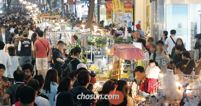 지난 25일 저녁 서울 명동 거리에서 노점상들이 각종 음식과 의류 등을 팔고 있다. 노점상 중에는 아르바이트생을 쓰며 하루 100만원대 매출을 올리는 곳도 있지만 사업자등록이 돼 있지 않아 세금은 한 푼도 내지 않는다.
