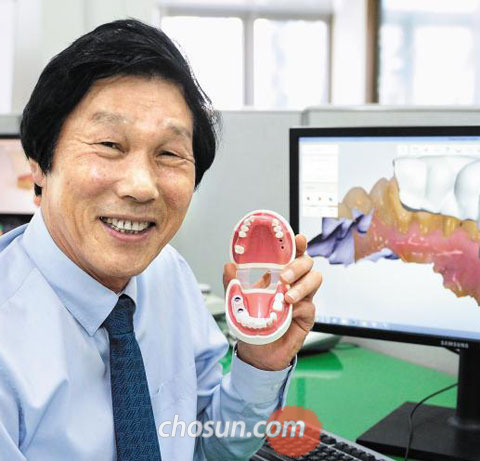부산 해운대구에 있는‘디오’본사에서 김진철 회장이 치아 여러 개가 빠져 구멍이 숭숭 나 있는 구강 구조 모형을 보여주고 있다.