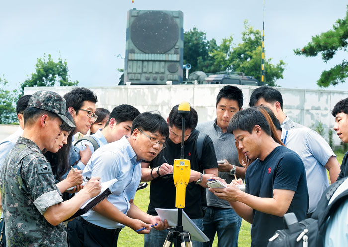 국방부 기자들이 군 관계자 안내에 따라 광대역 전자파 측정기에 찍힌 전자파 수치를 확인하는 모습.