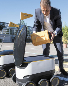 23일(현지 시각) 디터 밤바우어 스위스 우정국장이 우편물 배달 로봇에 물건을 담고 있다.