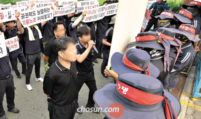 지난 9일 오전 충남 아산시 탕정면에 있는 갑을오토텍 공장을 점거한 노조원들(오른쪽) 앞에서 관리직 사원들(왼쪽)이“불법 점거 농성을 풀고 공장 진입을 허용하라”며 시위를 벌이고 있다.