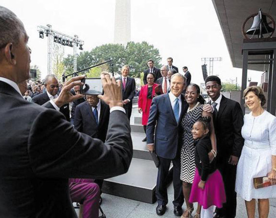 24일(현지 시각) 흑인역사박물관 개관식에서 오바마(맨 왼쪽) 대통령이 부시 전 대통령 부부와 한 흑인 가족의 기념사진을 찍어주고 있다.