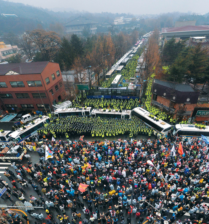 청와대 200m앞까지 진출 - 지난 26일 서울 광화문광장에서 열린 5차 촛불집회에 참가한 시민들이 청와대에서 200m쯤 떨어진 서울 청운효자동주민센터 앞에서 경찰과 대치하고 있다. 사진 왼쪽 위로 청와대 건물들이 보인다. 이날 집회에는 주최 측 추산 150만명(경찰 추산 27만여명)이 참여했다. 