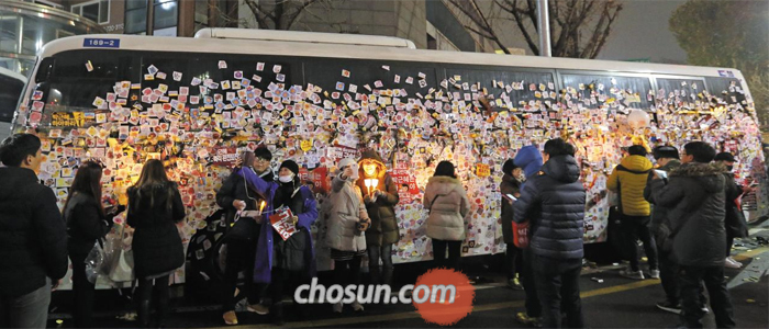 경찰 버스에 다양한 스티커 - 촛불집회 참가자들이 꽃무늬 스티커가 붙은 경찰버스를 배경으로 기념 사진을 찍고 있다. 몇몇은 집회 막바지에 스티커를 떼기도 했다.