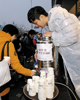 따뜻한 물 드세요 - 지난 26일 오후 서울 종로구 통인동의 한 커피점 운영자들이 촛불집회에 참가한 시민들에게 따뜻한 물을 나눠주고 있다.