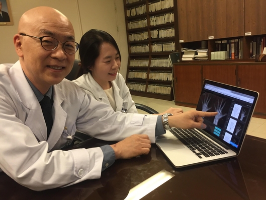  이진성 서울아산병원 영상의학과 교수(왼쪽)가 뷰노코리아와 공동 연구한 AI 기반 골 연령 판독 SW를 실제로 시연하고 있다./김민수 기자